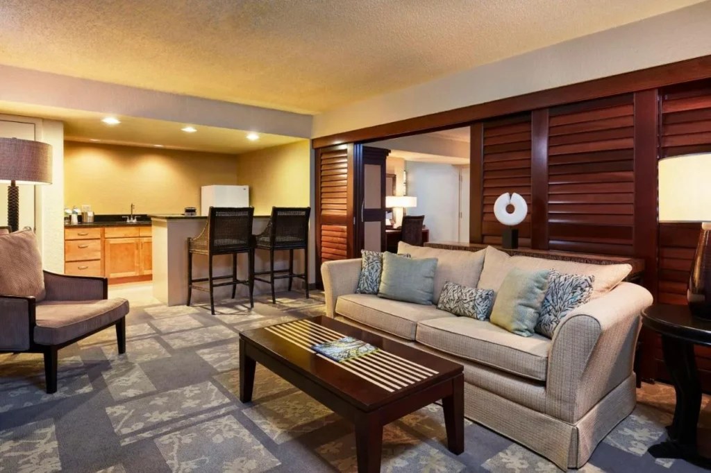 Suite living room with sofa and kitchen counter at the DoubleTree Orlando Theme Park Resort