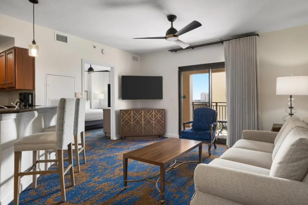 Sala de estar con sof&aacute;, barra de desayuno y puerta de balc&oacute;n en Club Wyndham Bonnet Creek