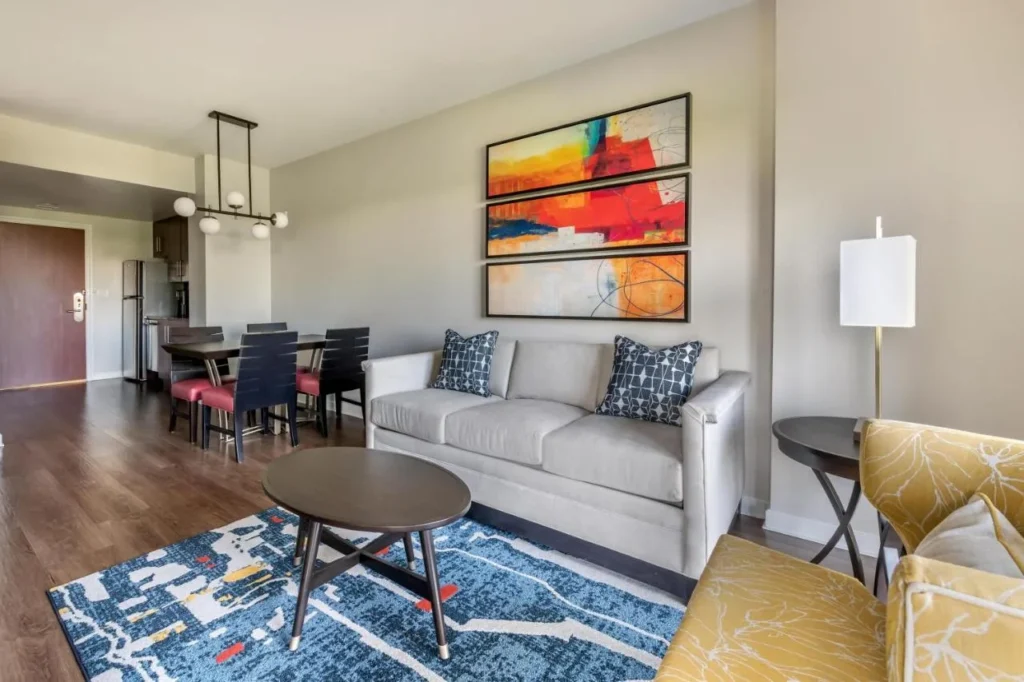 Suite living room with sofa, dining table and kitchen beyond at Las Palmeras