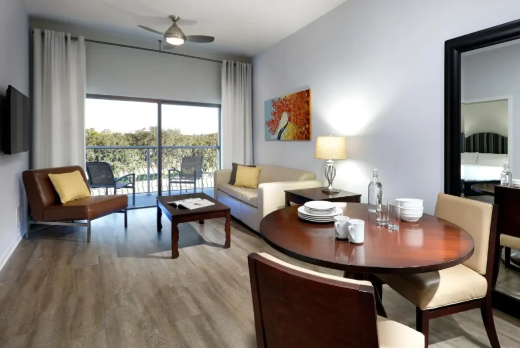Suite con sofá, mesa de comedor redonda y balcón en Meliá Orlando Celebration