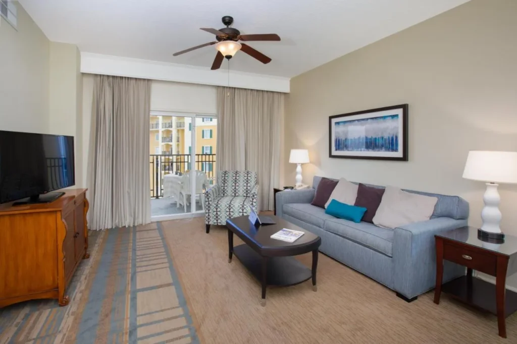 Suite living room with sofa, TV and balcony at Lake Buena Vista Resort Village and Spa