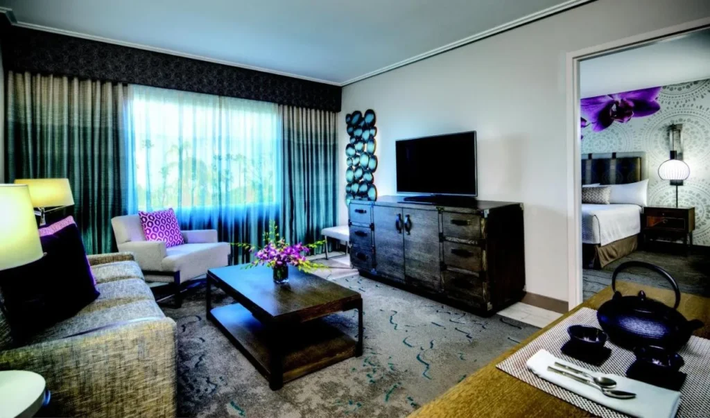 Sala de estar con sof&aacute;, TV y dormitorio en Loews Royal Pacific Resort