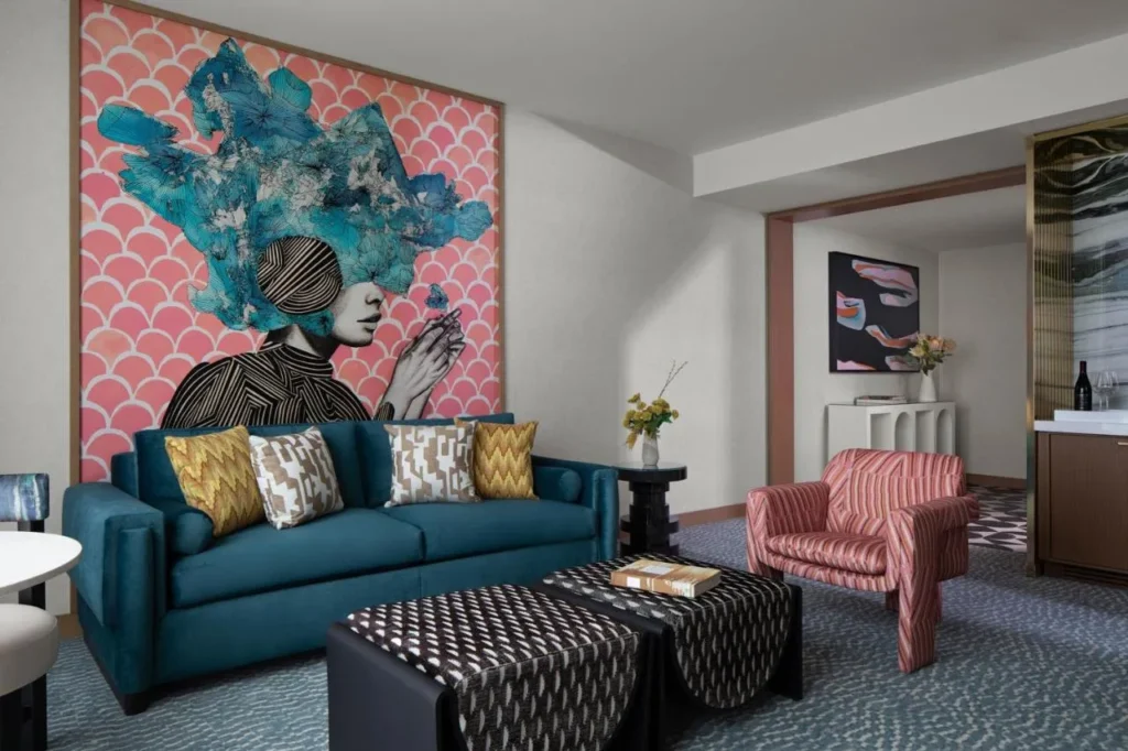 Sala de estar con sof&aacute; de color verde azulado, sill&oacute;n rosa y mural de pared en Lake Nona Wave Hotel