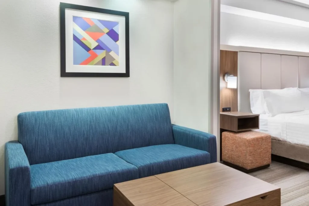 Suite sitting area with blue sofa and coffee table at Holiday Inn Express Nearest Universal Orlando