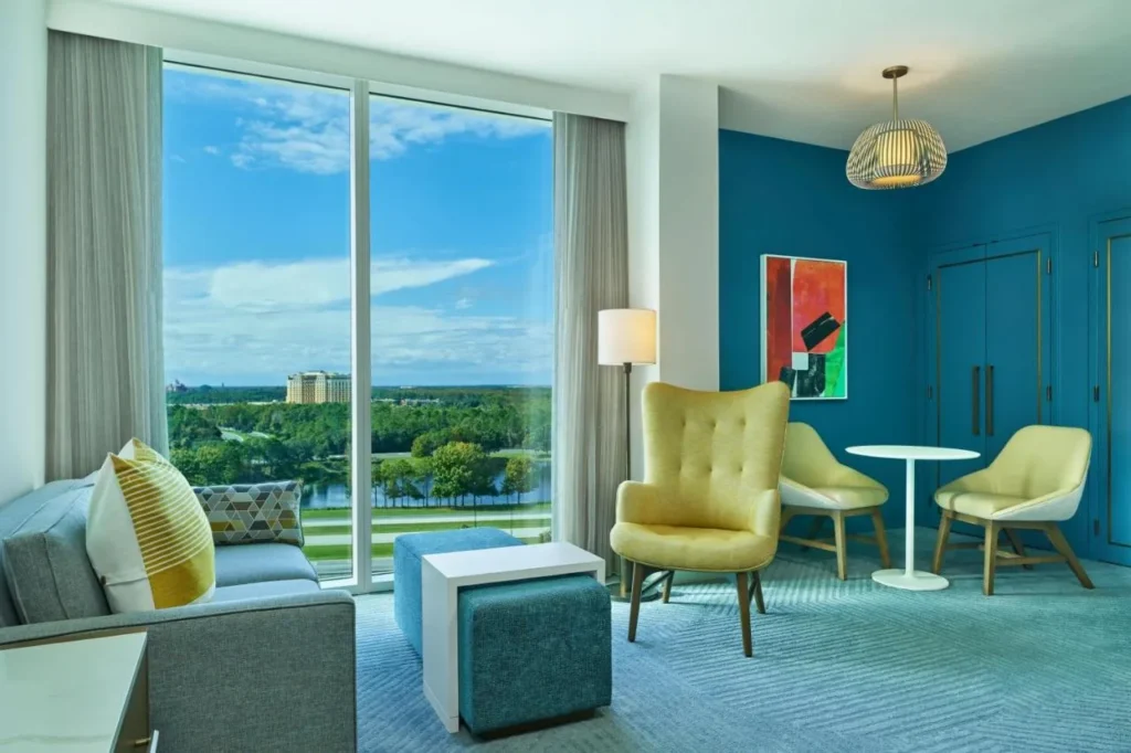 Suite sitting area with yellow armchairs and a lake-view window, Walt Disney World Swan Reserve