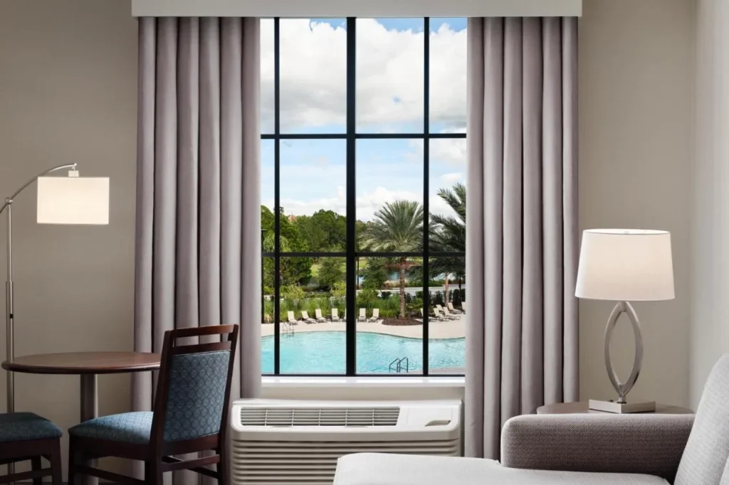 Suite window overlooking the pool and palm trees at Homewood Suites Flamingo Crossings