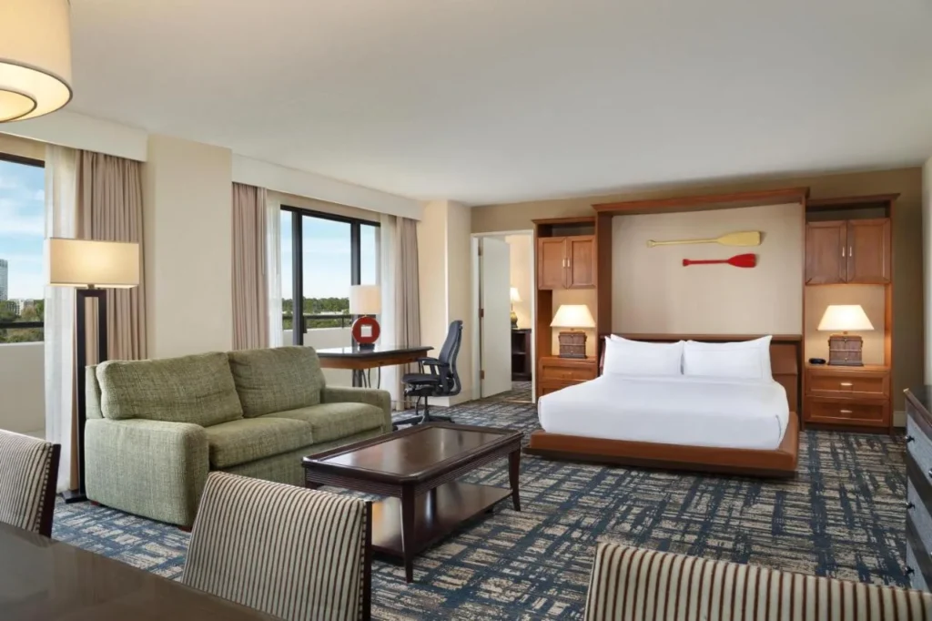Suite con cama king size y sof&aacute; verde en Hilton Orlando Lake Buena Vista