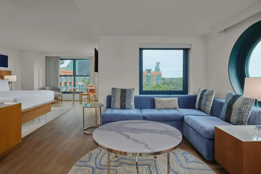 Suite con un sof&aacute; seccional y una ventana hacia el Delf&iacute;n en Walt Disney World Swan