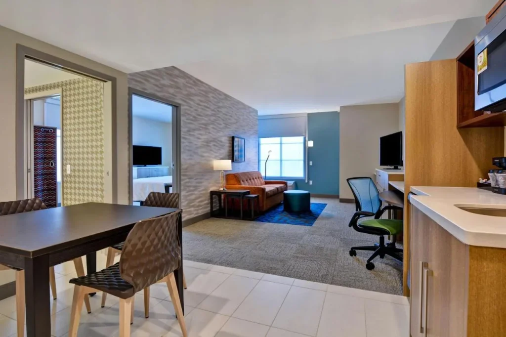 Suite con mesa de comedor, sala de estar y cocineta en Home2 Suites Orlando Flamingo Crossings