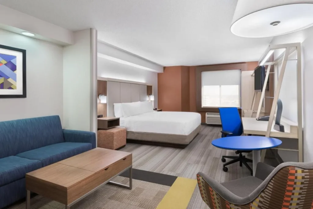 Suite with sofa, blue table and bed at Holiday Inn Express & Suites Nearest Universal Orlando