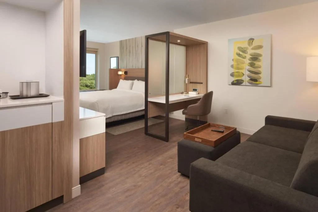 Suite con sof&aacute;, escritorio, estaci&oacute;n de caf&eacute; y cama king en el SpringHill Suites Orlando Lake Nona