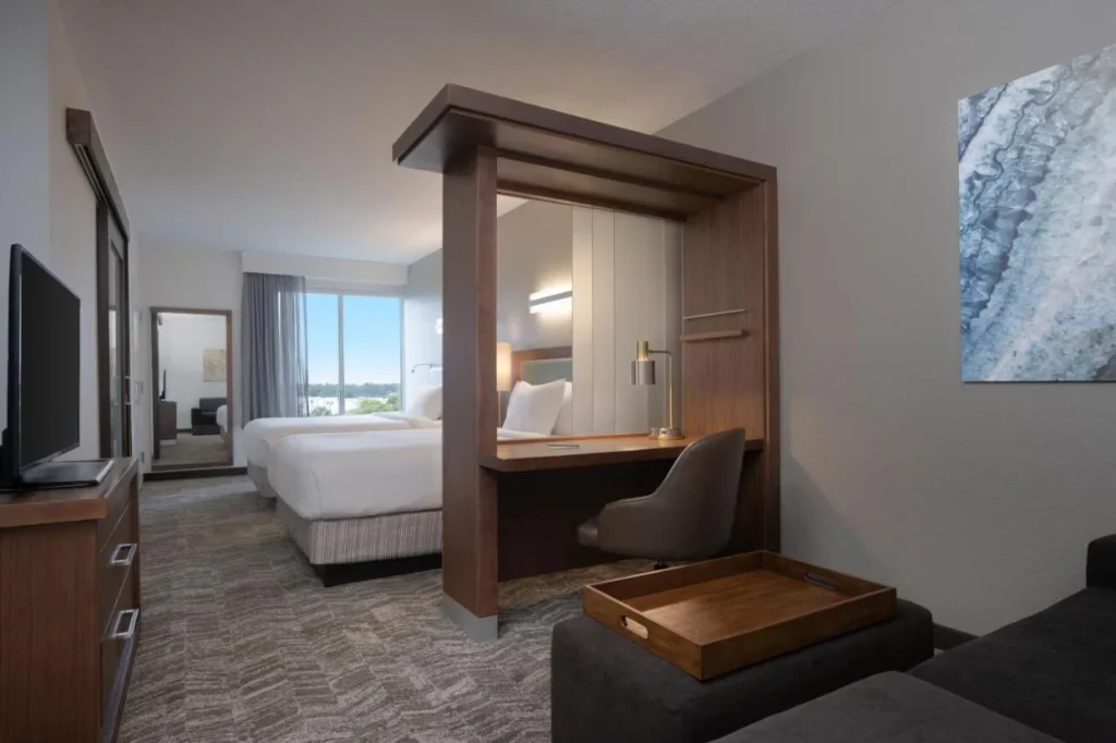Suite con dos camas, escritorio y sof&aacute; en SpringHill Suites Orlando at Flamingo Crossings