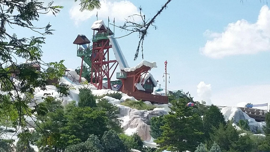 Summit Plummet's red ski-jump tower above snow-themed rocks at Disney's Blizzard Beach water park