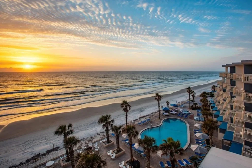 Sunrise over the Atlantic, the beach and the palm-lined pool deck at The Shores Resort & Spa