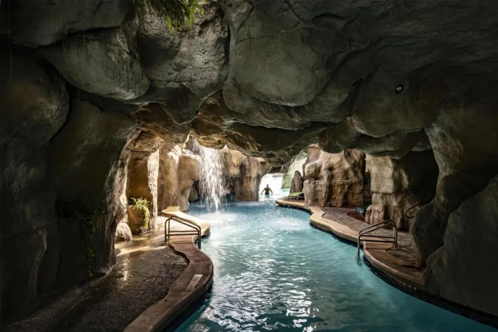 Nade a través de la gruta de roca con una cascada en la piscina de la laguna en Hyatt Regency Grand Cypress