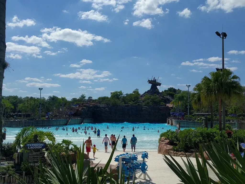 Nadadores en la piscina de surf Typhoon Lagoon con el bote varado en la cima de la montaña central