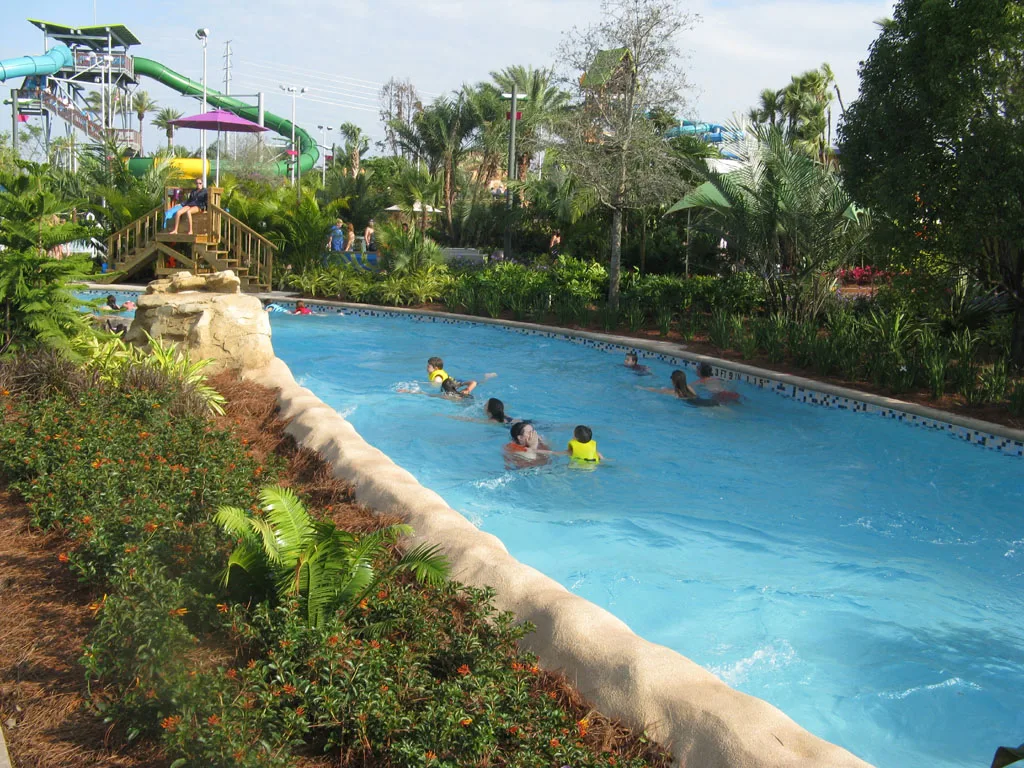 Los nadadores montan Roa's Rapids, el río de acción en Aquatica Orlando, más allá de la plantación tropical