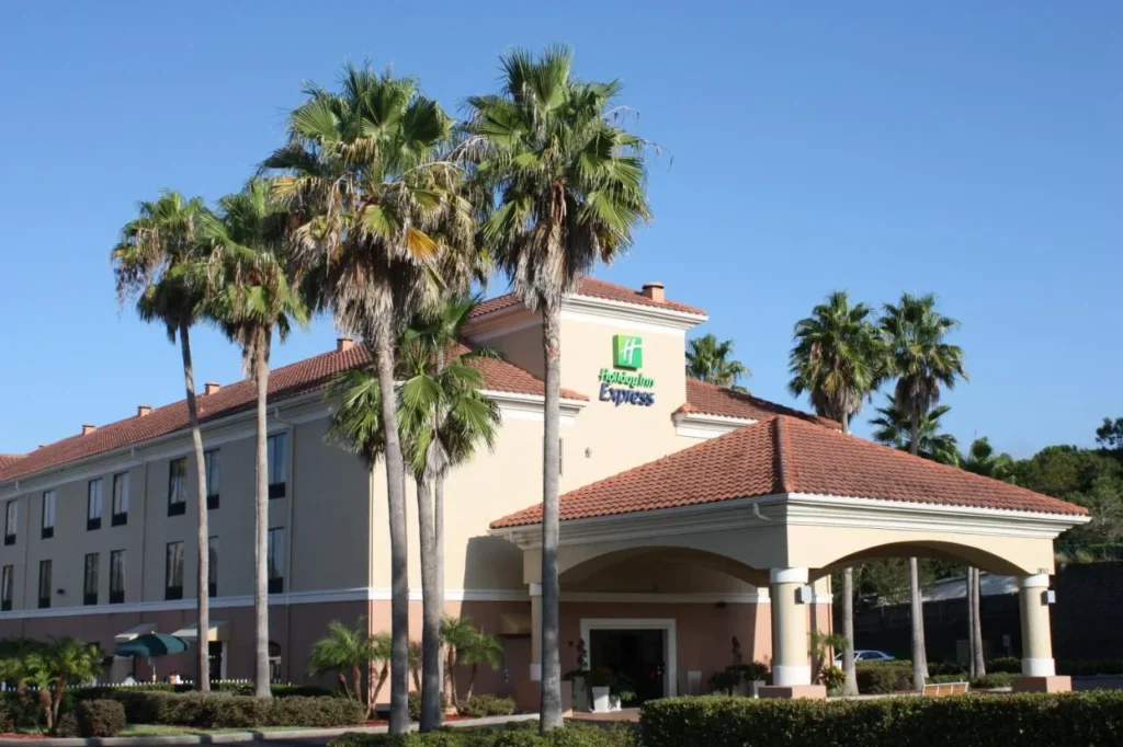 Tall palm trees in front of the tile-roofed entrance of Holiday Inn Express Clermont