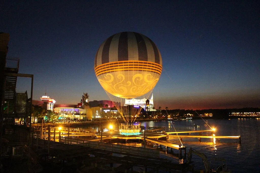 Tethered helium balloon glowing at dusk above the West Side lakefront at Disney Springs