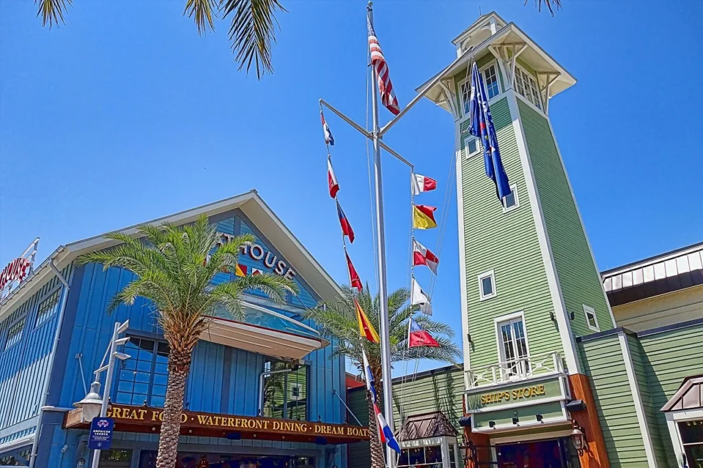 The Boathouse's blue waterfront building, nautical signal flags and a green tower at Disney Springs