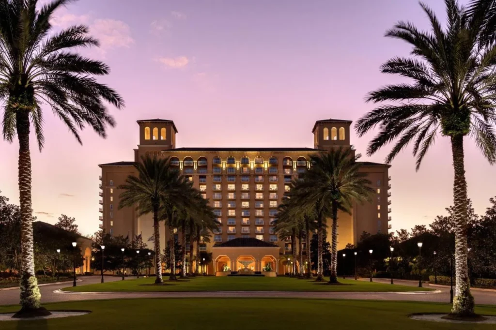The Ritz-Carlton Orlando, Grande Lakes tower and palm-lined entrance lawn at dusk