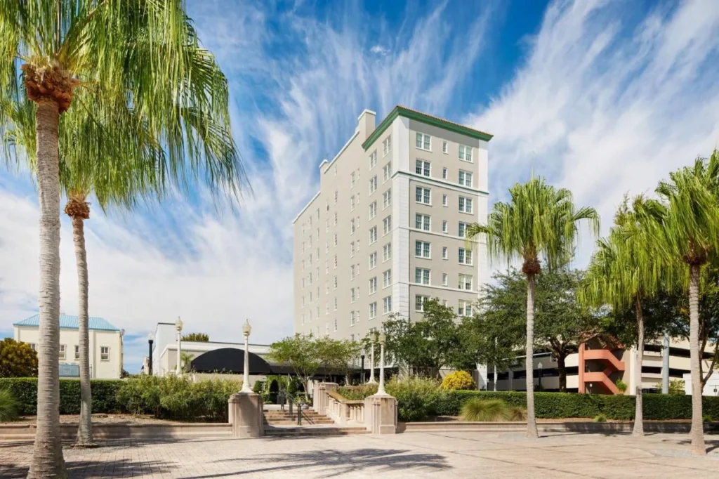 La pálida torre histórica del Terrace Hotel detrás de palmeras en el centro de Lakeland