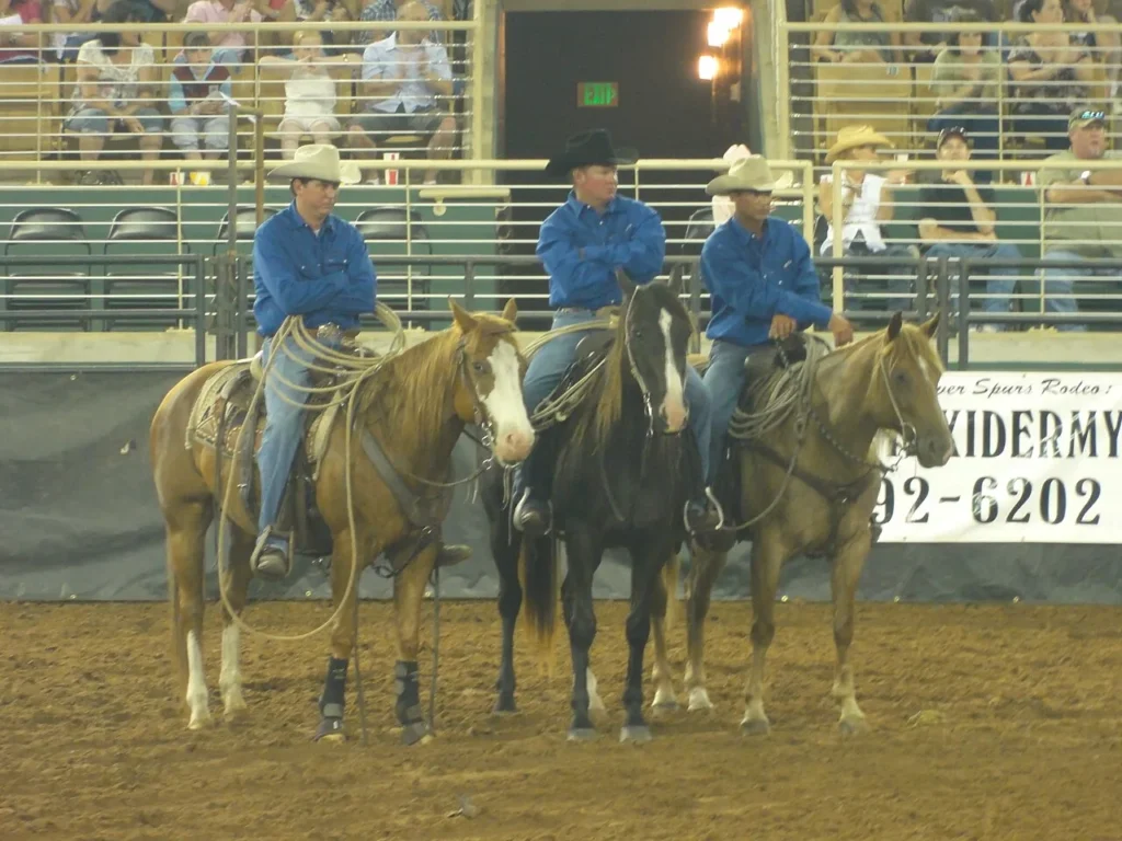 Tres vaqueros a caballo en la arena durante el Silver Spurs Rodeo en Kissimmee