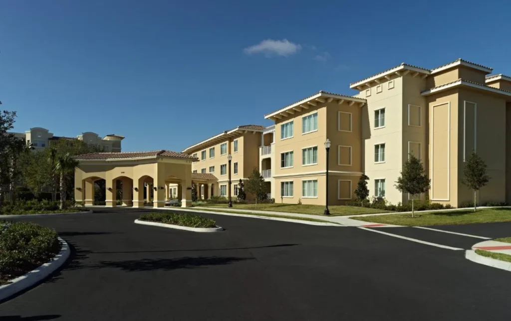 Three-story villa-style buildings and a covered drop-off area at Omni Orlando Resort at ChampionsGate