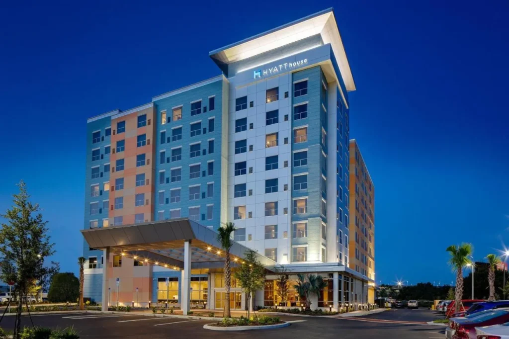 Hyatt House frente a la torre Universal Orlando Resort y el dosel de entrada iluminado al atardecer