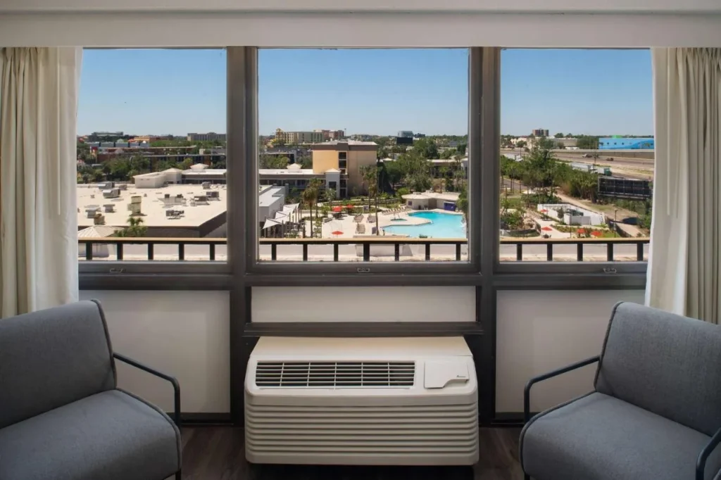 Tower room window with two gray armchairs overlooking the pool area at Wyndham I-Drive Avanti
