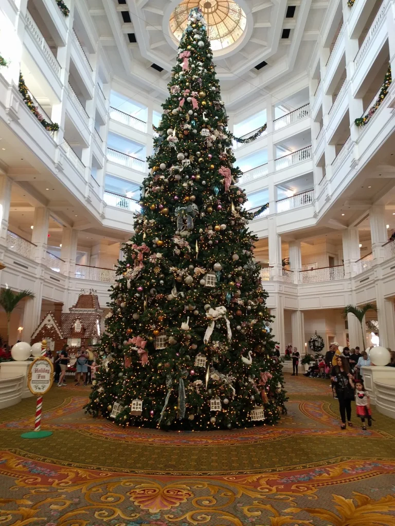 Towering Christmas tree with pink bows and birdcage ornaments in the Grand Floridian lobby