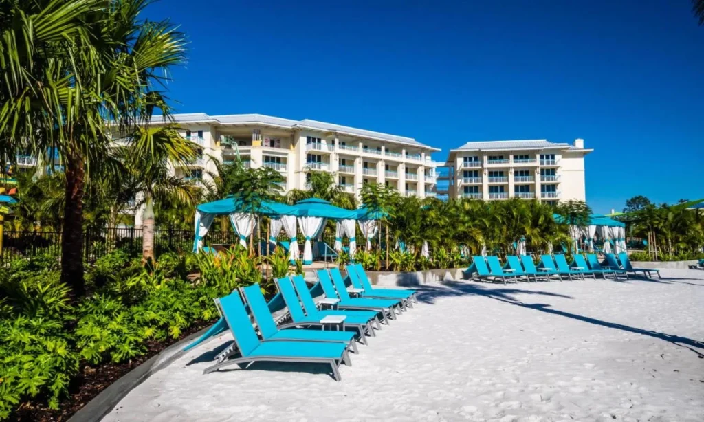 Tumbonas y cabañas turquesas en la playa de arena debajo de las villas en Margaritaville Resort Orlando