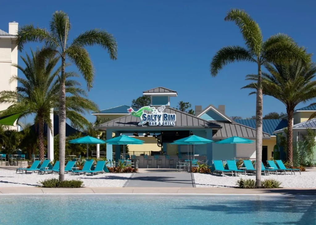 Tumbonas turquesas junto a la piscina y Salty Rim Bar & Grill en Margaritaville Resort Orlando