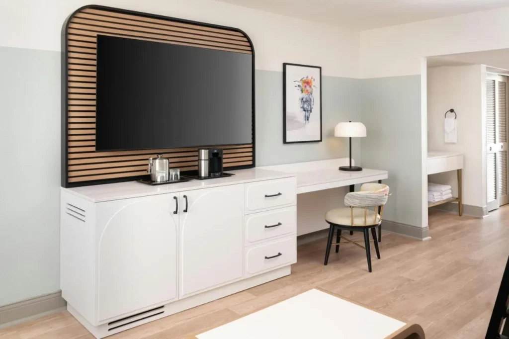 Consola de televisi&oacute;n con cafetera y escritorio en una habitaci&oacute;n Sheraton Lake Buena Vista renovada