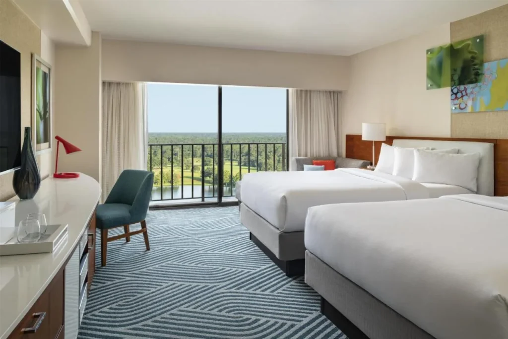 Habitación de dos camas con balcón y vistas a un lago en Hyatt Regency Grand Cypress