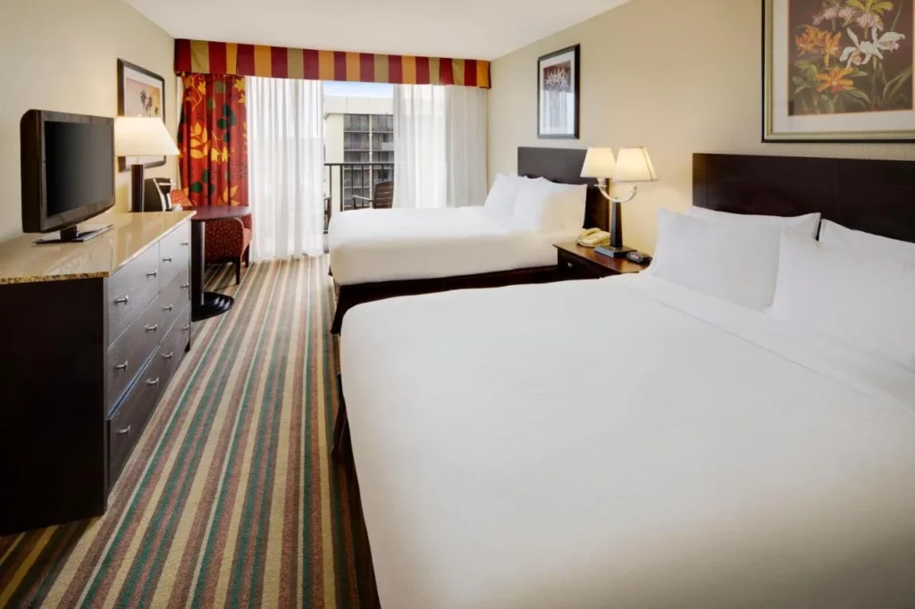 Habitación de dos camas con balcón y alfombra a rayas en Holiday Inn & Suites Orlando SW