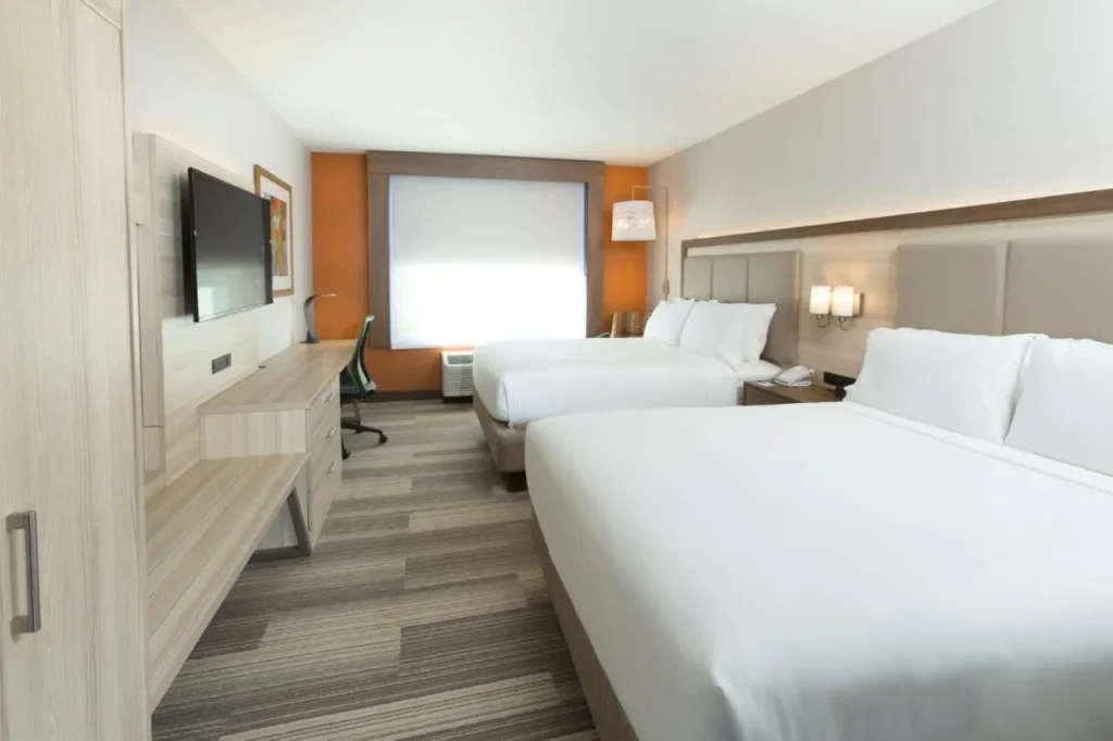 Habitación de dos camas con un escritorio largo en Holiday Inn Express & Suites S Lake Buena Vista