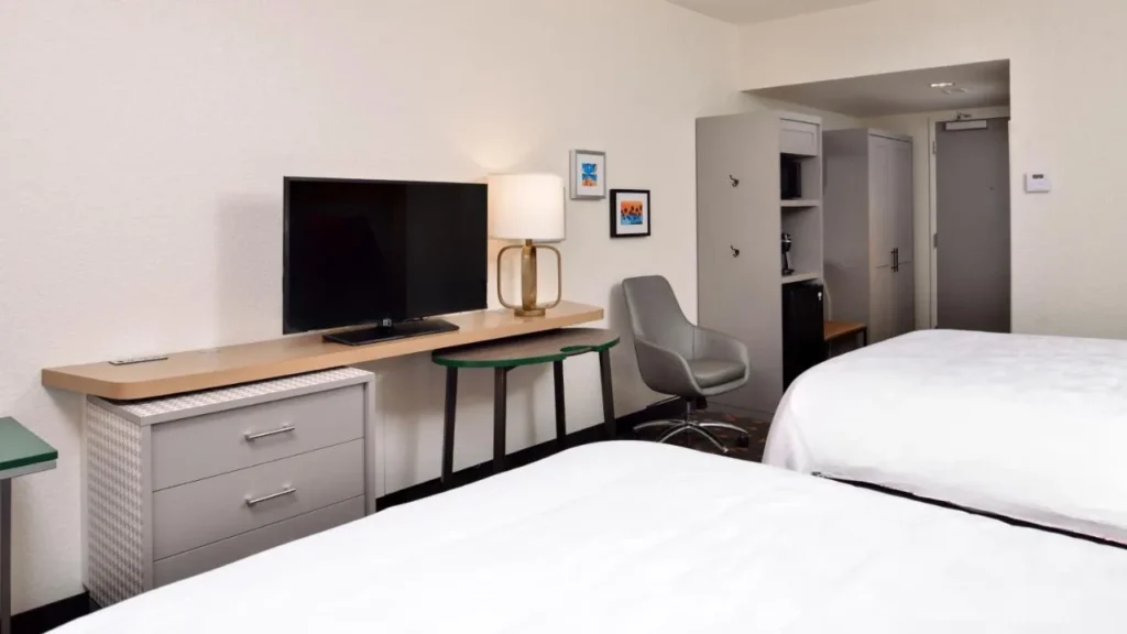 Habitaci&oacute;n de dos camas con un largo escritorio de TV en Holiday Inn & Suites I-Drive Theme Parks