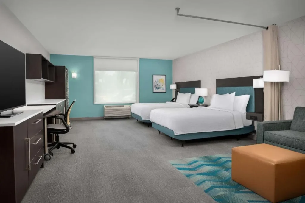 Suite estudio de dos camas con escritorio, gabinetes de pared, sill&oacute;n y otomana en Home2 Suites Orlando Southeast Nona