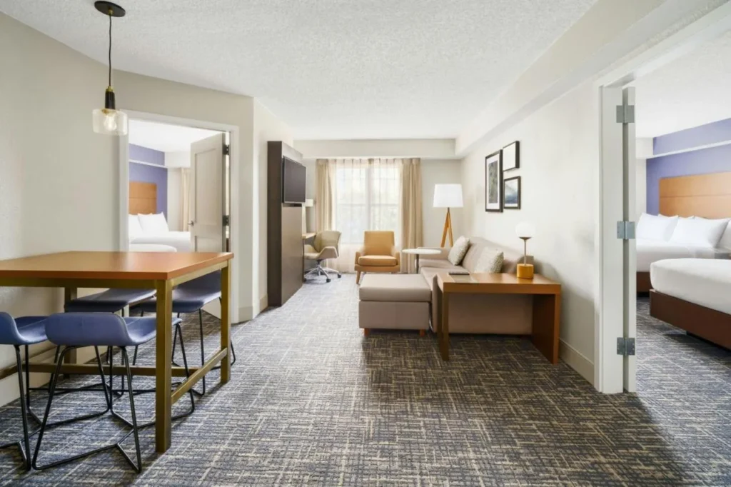 Suite de dos dormitorios con sof&aacute; y mesa de bar en el Residence Inn Orlando Lake Buena Vista