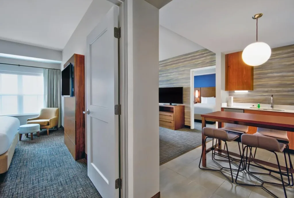 Suite de dos dormitorios con barra de cocina, sala de TV y dos dormitorios en el Residence Inn Flamingo Crossings