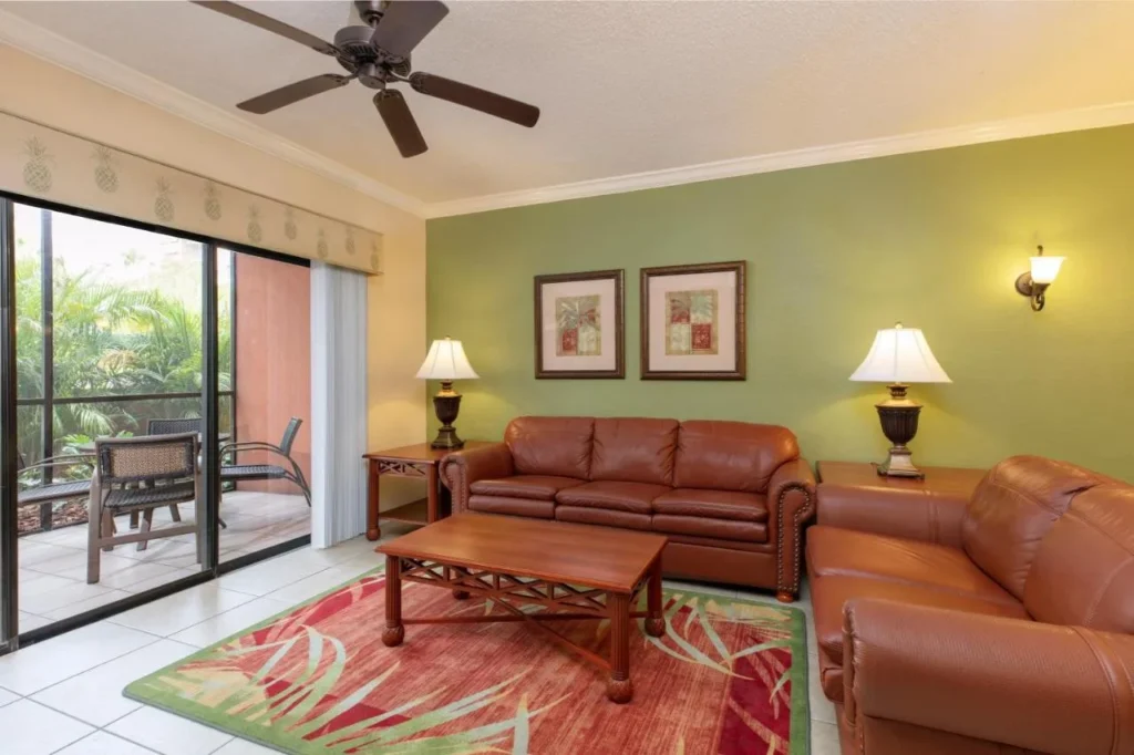 Two-bedroom villa living room with leather sofas and a screened patio at Westgate Lakes Resort