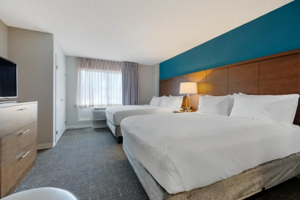 Dos camas y una c&oacute;moda en un dormitorio suite en Staybridge Suites Orlando Royale Parc Suites