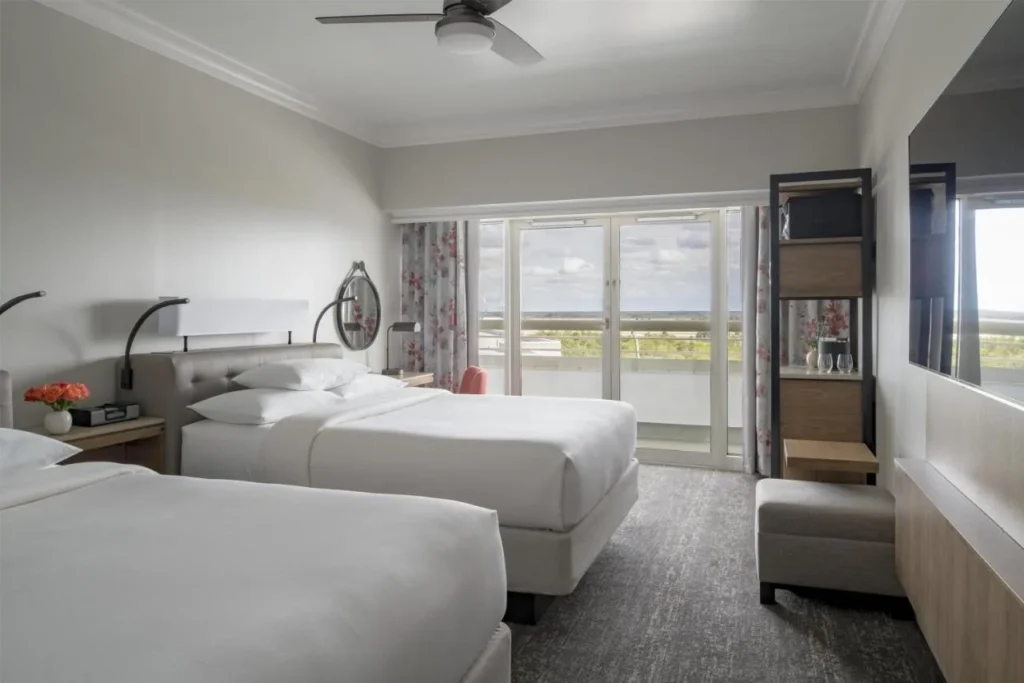 Habitaci&oacute;n con dos camas y puertas de vidrio a un balc&oacute;n en Hyatt Regency Orlando International Airport