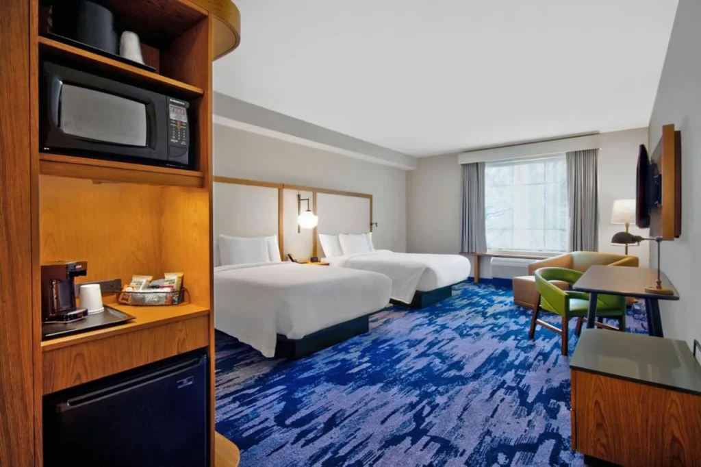 Dos camas, microondas y mini nevera en una habitación Fairfield Inn & Suites Flamingo Crossings