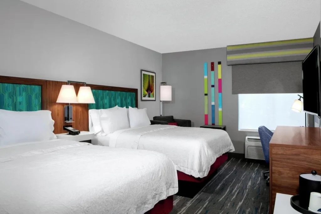 Dos camas con cabeceros de color verde azulado y un escritorio en Hampton Inn Orlando/Lake Buena Vista
