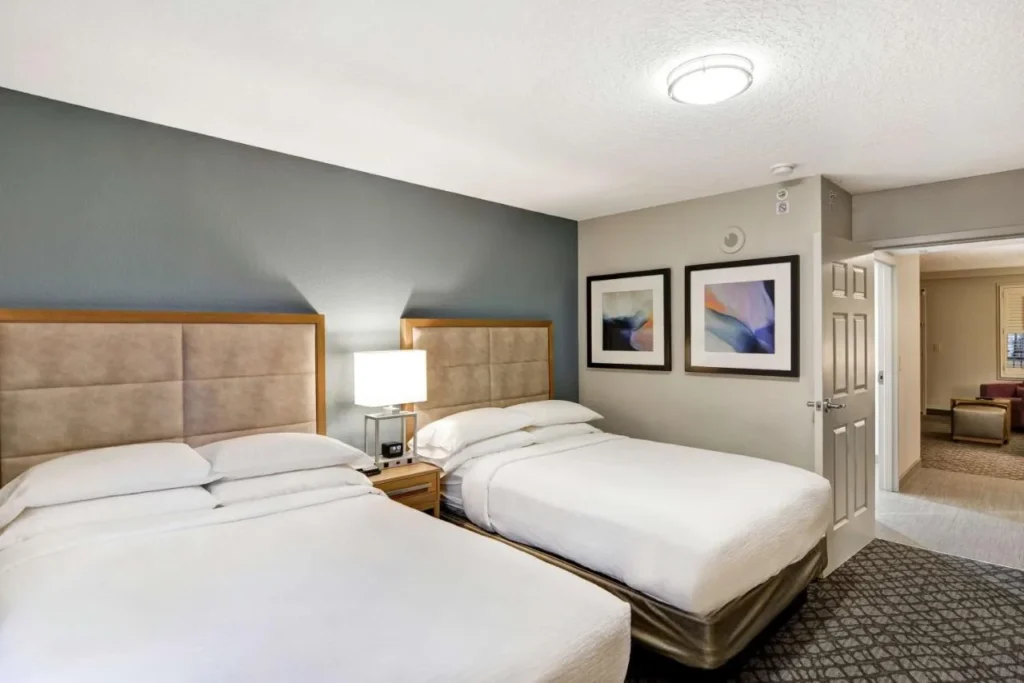 Two-double-bed bedroom opening to the living room at Embassy Suites Orlando Downtown