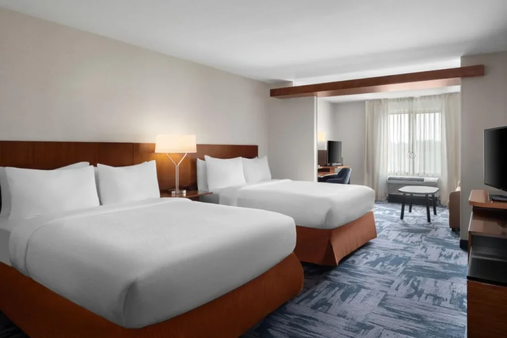 Two queen beds and a sitting nook at Fairfield Inn and Suites Kissimmee/Celebration