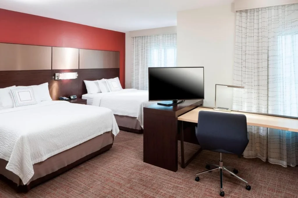 Dos camas queen, escritorio y TV en una suite en el Residence Inn Near Universal Orlando