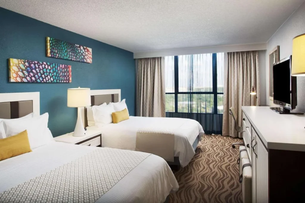 Dos camas queen, c&oacute;moda y ventana grande en una habitaci&oacute;n de la torre Wyndham Lake Buena Vista